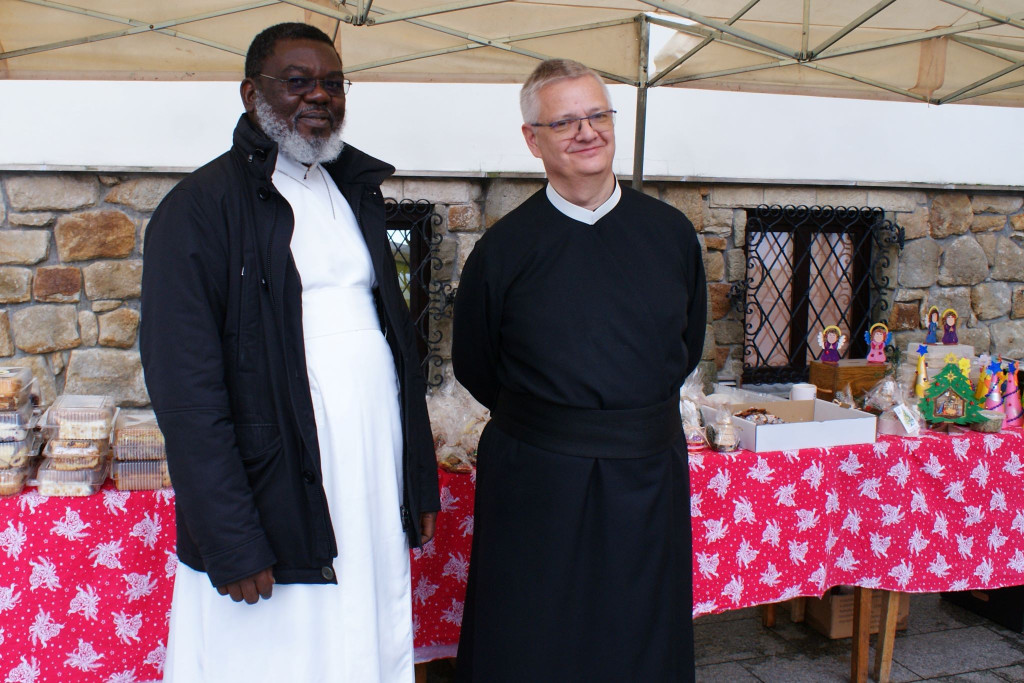 Redemptorysta z Afryki oraz Redemptorysta z Polski pozują do zdjęcia podczas kiermaszu świątecznego