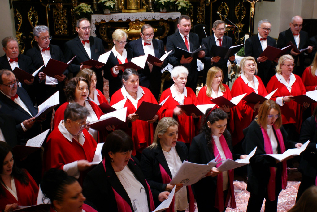 Chórzyści śpiewają na schodach prezbiterium Bazyliki Mniejszej w Tuchowie podczas koncertu kolęd