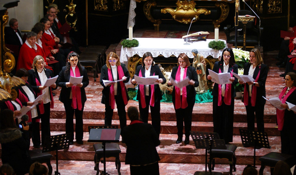 Chórzyści śpiewają na schodach prezbiterium Bazyliki Mniejszej w Tuchowie podczas koncertu kolęd