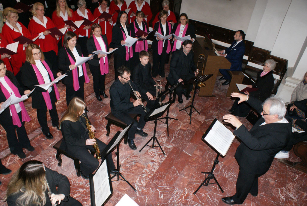 Chórzyści śpiewają na schodach prezbiterium Bazyliki Mniejszej w Tuchowie podczas koncertu kolęd
