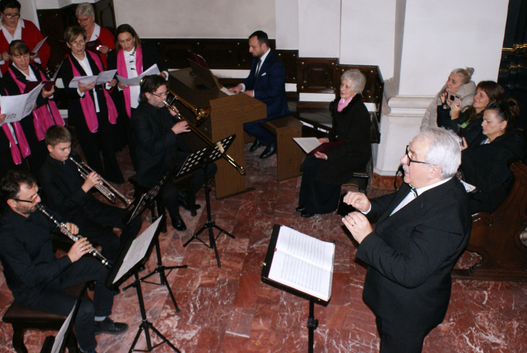 Chórzyści śpiewają na schodach prezbiterium Bazyliki Mniejszej w Tuchowie podczas koncertu kolęd